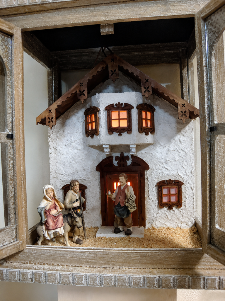 Tiroler Bauernkrippenlaterne mit Herbergsuche und beleuchtetem Bauernhaus